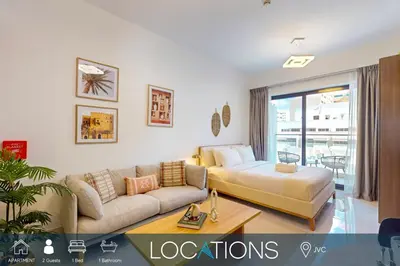a living room with a couch and a table at Avanos Residence - Captivating Studio in JVC in Dubai