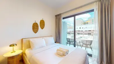 a bedroom with a bed and a large window at Avanos Residence - Captivating Studio in JVC in Dubai