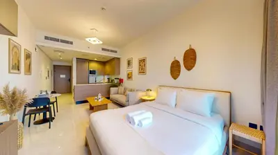 a bedroom with a large bed and a living room at Avanos Residence - Captivating Studio in JVC in Dubai
