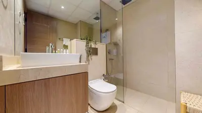 a bathroom with a toilet and a sink and a shower at Avanos Residence - Captivating Studio in JVC in Dubai