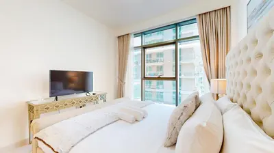 a bedroom with a white bed with a large window at Beach Vista 2 - Two Bedroom with Partial Sea View in Dubai