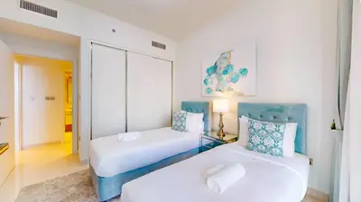 two beds in a room with white and blue at Beach Vista 2 - Two Bedroom with Partial Sea View in Dubai