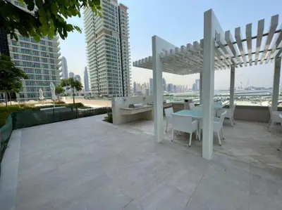 a patio with a table and chairs and buildings at Beach Vista 2 - Two Bedroom with Partial Sea View in Dubai