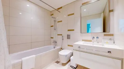a bathroom with a tub and a toilet and a sink at Beach Vista 2 - Two Bedroom with Partial Sea View in Dubai