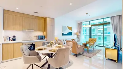 a kitchen and living room with a table and chairs at Beach Vista 2 - Two Bedroom with Partial Sea View in Dubai