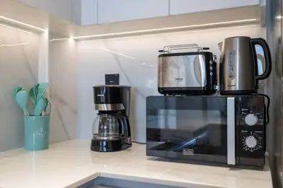 a microwave sitting on top of a kitchen counter at Luxurious 1-Bedroom Oasis l Binghatti Corner, JVC in Dubai
