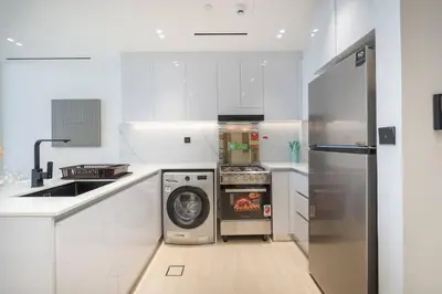 a kitchen with a washer and dryer in it at Luxurious 1-Bedroom Oasis l Binghatti Corner, JVC in Dubai