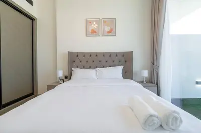 a bedroom with a large white bed with towels on it at Luxurious 1-Bedroom Oasis l Binghatti Corner, JVC in Dubai