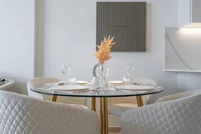 a dining room with a glass table and chairs at Luxurious 1-Bedroom Oasis l Binghatti Corner, JVC in Dubai