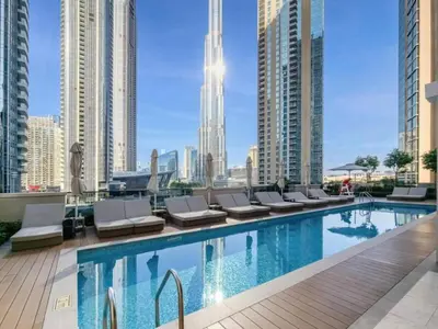 a swimming pool with lounge chairs and a city skyline at Stylish 2 Bed with Stunning Burj Khalifa View in Downtown in Dubai