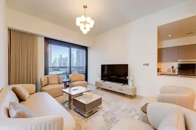 a living room with white furniture and a flat screen tv at Stylish 2 Bed with Stunning Burj Khalifa View in Downtown in Dubai