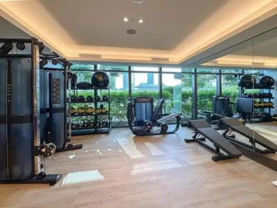 a gym with treadmills and ellipticals in a room with windows at Gorgeous High Floor 3-Bed with Full Burj View in Dubai