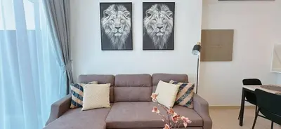 a living room with a couch and two tigers on the wall at Stylish 1br Apt Jvc W Pool & Free Parking in Dubai