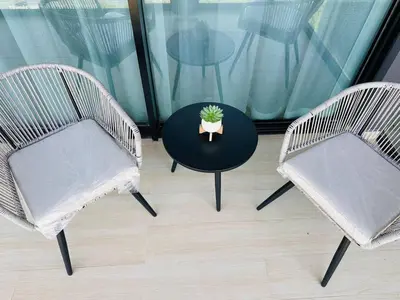 three chairs and a table with a potted plant on it at Stylish 1br Apt Jvc W Pool & Free Parking in Dubai