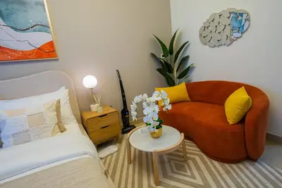 a living room with a couch and a table at Elegant Studio with Pool Access & Private Terrace in Dubai