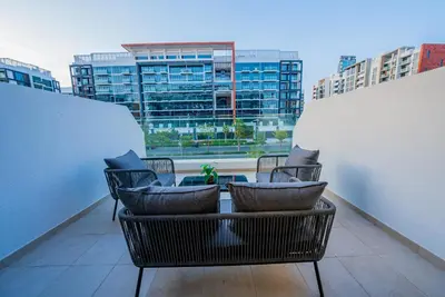 a balcony with chairs and a table on a building at Elegant Studio with Pool Access & Private Terrace in Dubai