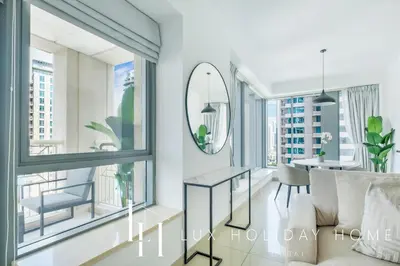 a living room with a table and windows at LUX The Fountain View Suite in Dubai