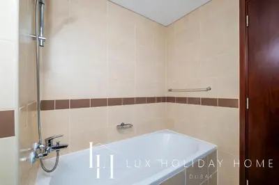 a bath tub in a bathroom with a shower at LUX The Fountain View Suite in Dubai