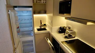 a small kitchen with a refrigerator and a stove at Splendid Cozy Studio - Address Dubai Marina in Dubai
