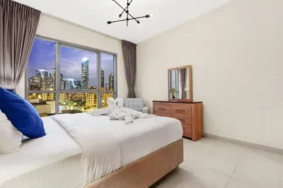 a bedroom with a large bed and a large window at Chic City Apartment in Dubai Gym, Pool, and Free Parking in Dubai