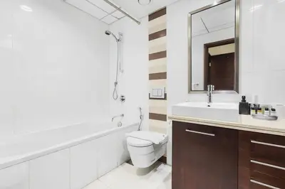 a bathroom with a toilet and a sink and a mirror at Chic City Apartment in Dubai Gym, Pool, and Free Parking in Dubai