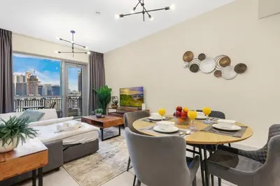 a living room with a table and a couch at Chic City Apartment in Dubai Gym, Pool, and Free Parking in Dubai