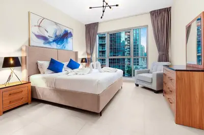 a bedroom with a bed and a chair and a window at Chic City Apartment in Dubai Gym, Pool, and Free Parking in Dubai