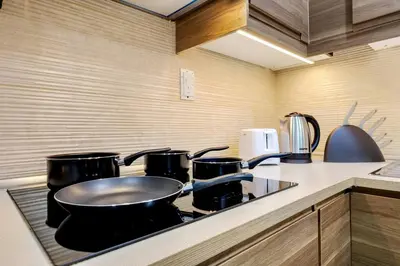 a kitchen with a stove with pots and pans on it at 4BR Jumeirah Beach Stay with Dubai Eye Views & Near Marina Walk in Dubai