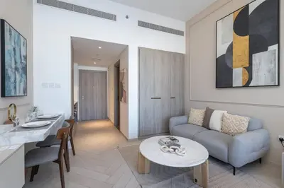 a living room with a couch and a table at Beautiful Pool View JVC Cozy and Stylish Czechin in Dubai