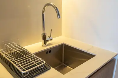 a kitchen sink with a faucet on a counter at Beautiful Pool View JVC Cozy and Stylish Czechin in Dubai