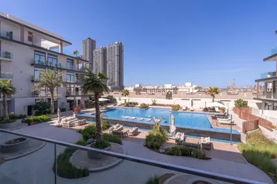 a swimming pool with chaise lounges and a resort at Beautiful Pool View JVC Cozy and Stylish Czechin in Dubai