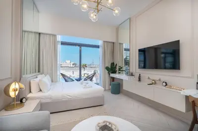 a bedroom with a bed and a tv and a couch at Beautiful Pool View JVC Cozy and Stylish Czechin in Dubai
