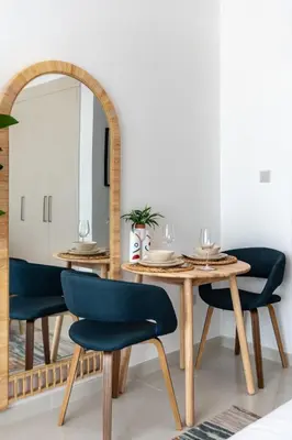 a dining room with a table and chairs and a mirror at GuestReady - Elegant retreat at Damac Hills in Dubai