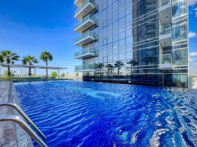 a swimming pool in front of a building at GuestReady - Elegant retreat at Damac Hills in Dubai