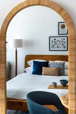 a bedroom with a large bed with a blue chair at GuestReady - Elegant retreat at Damac Hills in Dubai