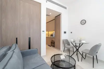 a living room with a blue couch and a table at TOP Location and Work and Chill near Miracle Garden in Dubai