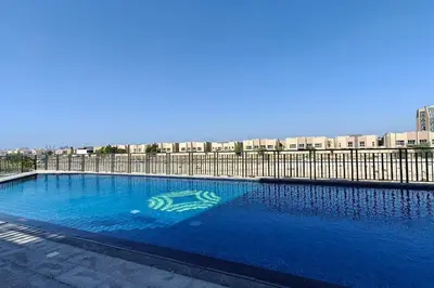 a large blue swimming pool next to a fence at TOP Location and Work and Chill near Miracle Garden in Dubai
