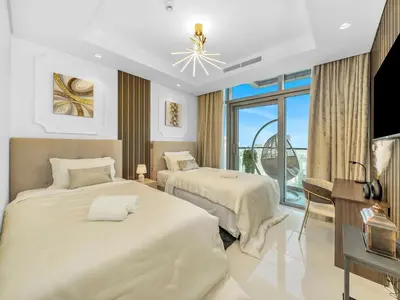 a hotel room with two beds and a television at Stunning 2BR with Burj View & Infinity Pool in Dubai