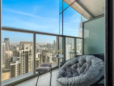 a room with a chair and a view of the city at Stunning 2BR with Burj View & Infinity Pool in Dubai