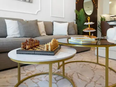 a living room with a couch and a table with a chessboard at Stunning 2BR with Burj View & Infinity Pool in Dubai