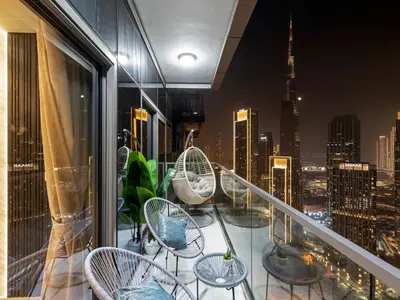 a balcony with chairs and a view of a city at Stunning 2BR with Burj View & Infinity Pool in Dubai