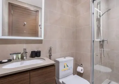 a bathroom with a toilet and a sink and a shower at Fully Furnished 2 Bed in Sobha Creek Vista Reserve, Hosted by Desert City Stays in Dubai