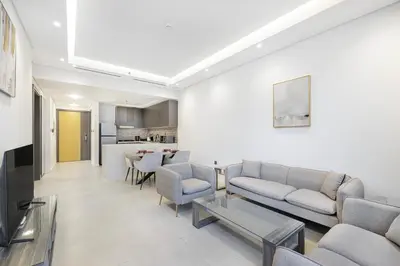 a living room with a couch and chairs and a table at Daniels 1BR at Jumeirah Garden City in Dubai