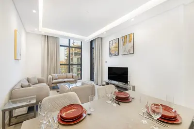 a dining room and living room with a table and chairs at Daniels 1BR at Jumeirah Garden City in Dubai