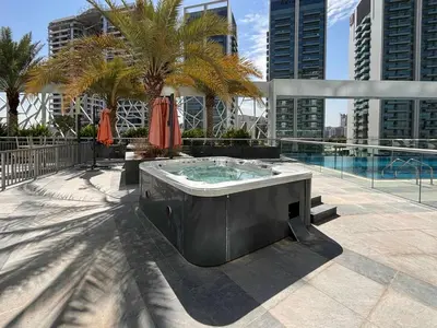 a hot tub on a patio next to a pool at Frank Porter - Bella Rose in Dubai