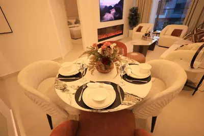 a dining room table with chairs and a table with plates and flowers at VIP Experience Dubai Nad Al Sheba at Prime Views- Opposite Al Meydan Hotel- Modern Luxury Apartment in Dubai