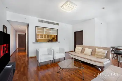 a living room with a couch and two white chairs at One Bed with Burj Khalifa View in Dubai