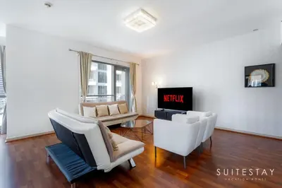 a living room with white furniture and a tv at One Bed with Burj Khalifa View in Dubai