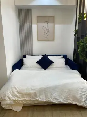 a bedroom with a large white bed with a blue headboard at Upgraded Luxury Studio Apartment - Marina View - 5-Star Hotel Amenities in Dubai
