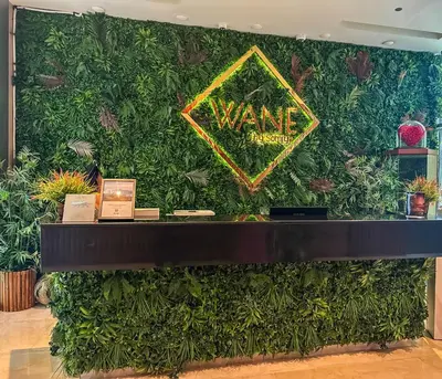 a wall covered in green plants with a sign on it at Upgraded Luxury Studio Apartment - Marina View - 5-Star Hotel Amenities in Dubai
